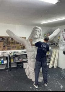Escultura monumental y gigante de la figura de Cristo con los brazos abiertos en taller durante su etapa de ensamble y acabado, fabricada mediante impresión 3D por CR Studio 3D en Medellín.
