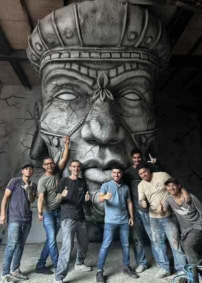 El equipo de trabajo y escultores posando frente a la obra monumental terminada "El Chamán" en la Galería Origen de la Comuna 13, fabricada mediante impresión 3D por CR Studio 3D en Medellín.