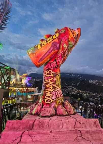 Fotografía nocturna de la escultura monumental "Mano Aerosol" iluminada en el Mirador 1520 de la Comuna 13, fabricada mediante impresión 3D en Medellín por CR Studio 3D.