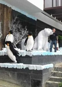 Vista panorámica desde otra perspectiva del proyecto de tematización en jardín privado con múltiples esculturas de pingüinos, oso polar y bloques de hielo, fabricado por CR Studio 3D en Medellín.